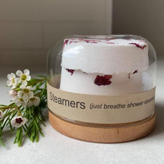 125g bamboo and glass reusable jar with lid on, containing two "just breathe" shower steamers" with rose petals on top.